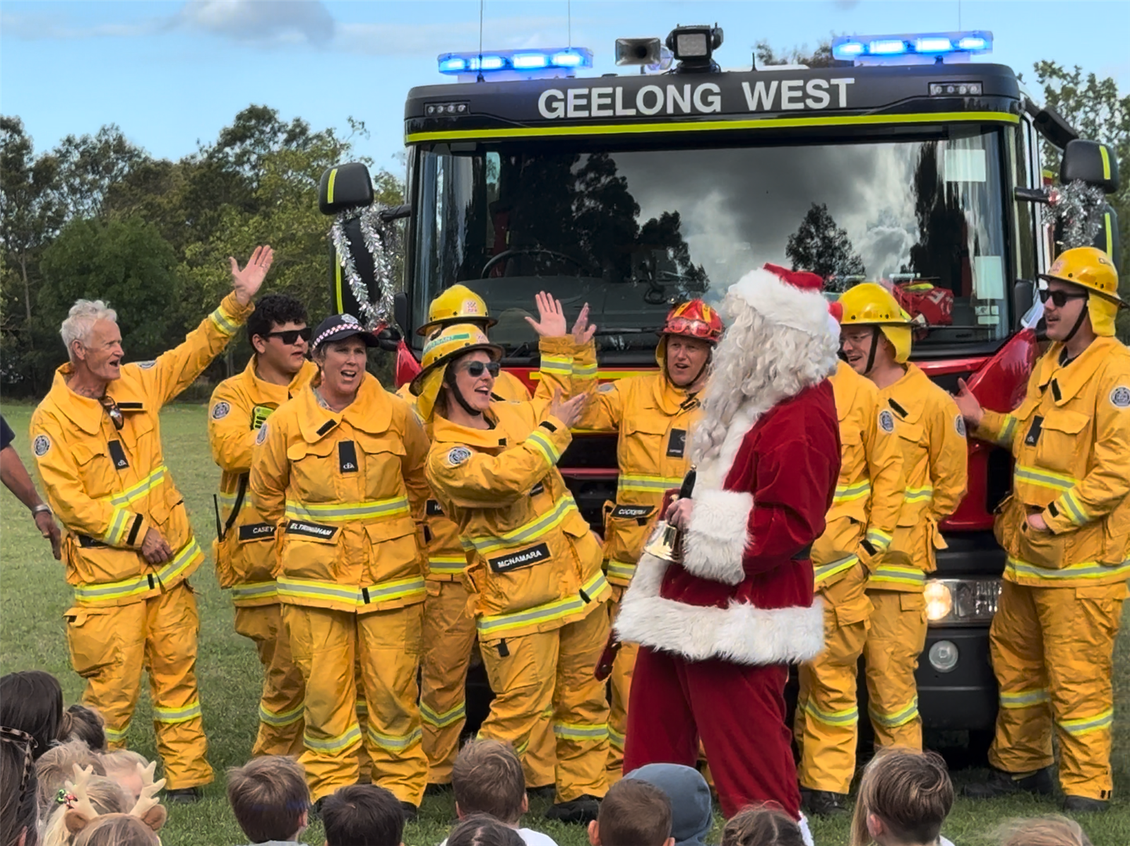 Santa spreads Christmas cheer in front of the fire truck with the Geelong West firefighters singing their hearts out.